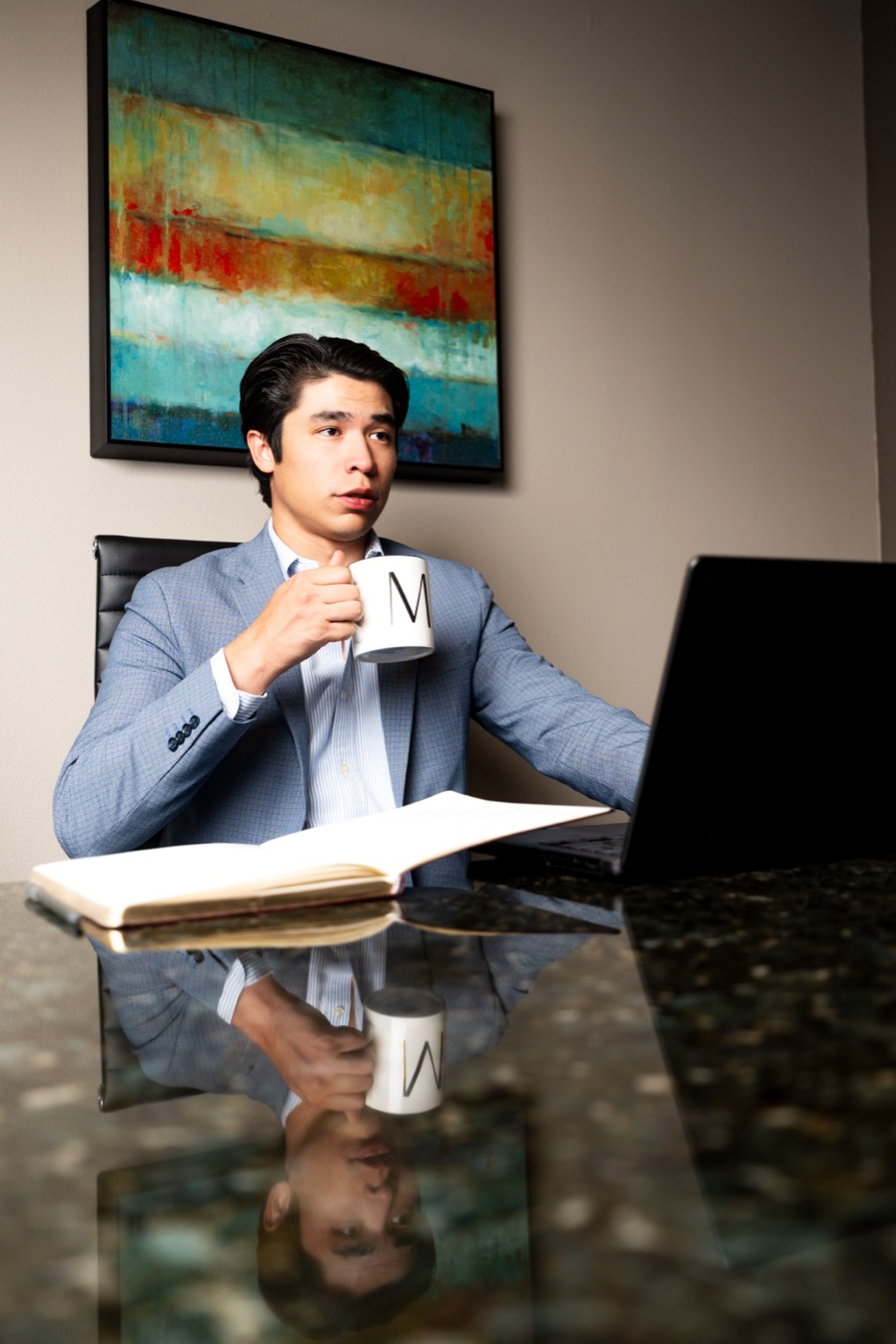Michael Munoz at his desk reviewing a client's books over coffee